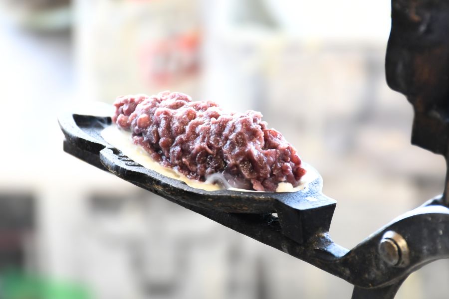 たい焼きにあんこを包んでいる様子